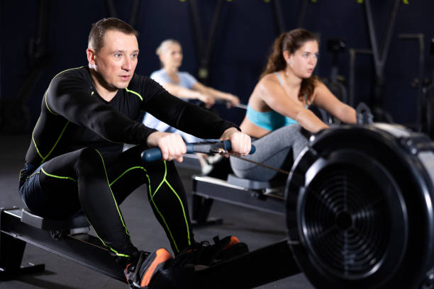 istock Athlete is engaged in the gym, man works on rowing simulator 1479292694