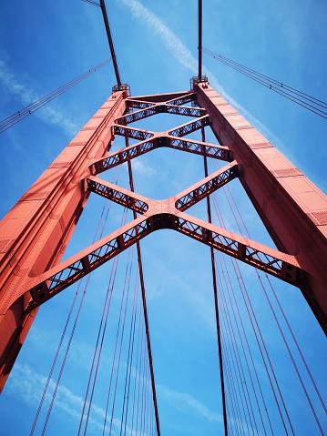 Pillar of the 25 de Abril bridge, the blue sky contrasting with the red of the bridge