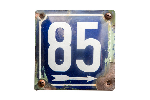 Weathered grunge square metal enameled plate of number of street address with number 85 isolated on white background