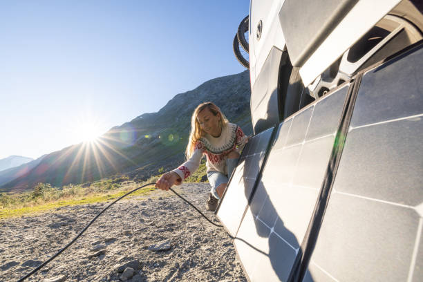 istock Woman using solar panels to get power for her van, the van life concept, self sufficiency with renewable energy 1479303842