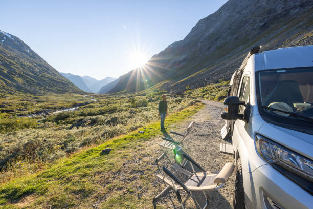 istock Man relaxing near camper van at sunset, van life concept 1479305026