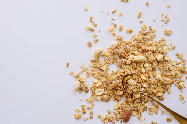 istock Granola on spoon isolated on white background, copy space. Healthy snack or breakfast concept - homemade granola with grains and nuts 1479307546