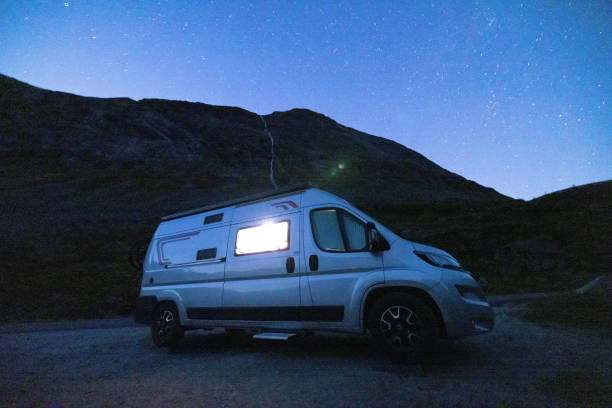 istock A camper van illuminated from inside standing on a high plateau, starry night without moon at night. 1479308130