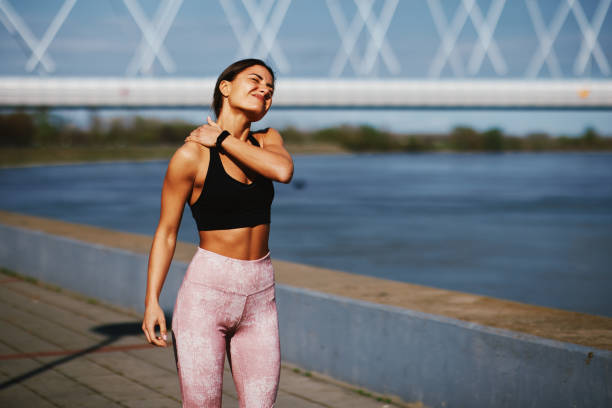 Young fitness woman injured her neck while jogging stock photo