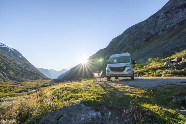 Van parked on a mountain pass at sunset, mountain view