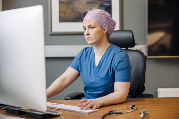 Female doctor working on desktop computer in office stock photo