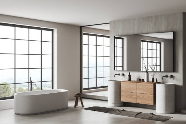 istock Stylish bathroom interior with double sink and tub, accessories and window 1479309283