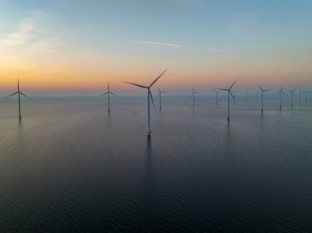 istock Wind turbines in an offshore wind park producing electricity during sunset. 1479311787