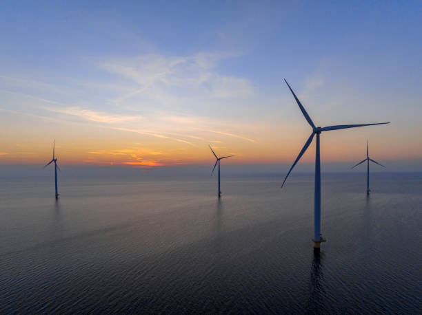 istock Wind turbines in an offshore wind park producing electricity during sunset. 1479311796