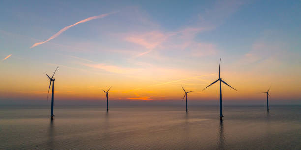 istock Wind turbines in an offshore wind park producing electricity during sunset. 1479312267