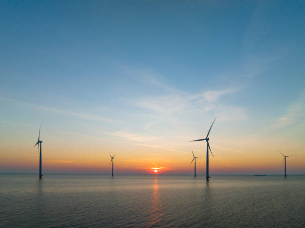 istock Wind turbines in an offshore wind park producing electricity during sunset. 1479312766