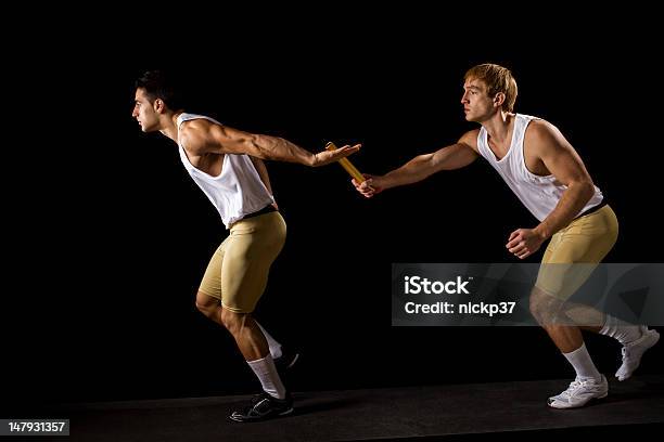 Two Men Running While The Other Passes A Baton Stock Photo - Download Image Now - Relay, Relay Baton, Passing - Sport