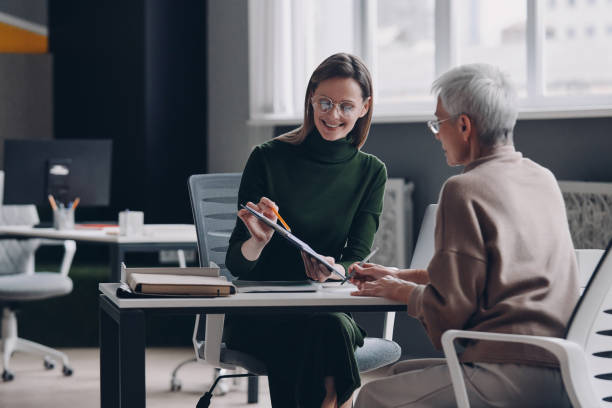 istock Senior woman discussing options with financial advisor while sitting in the office together 1479314471
