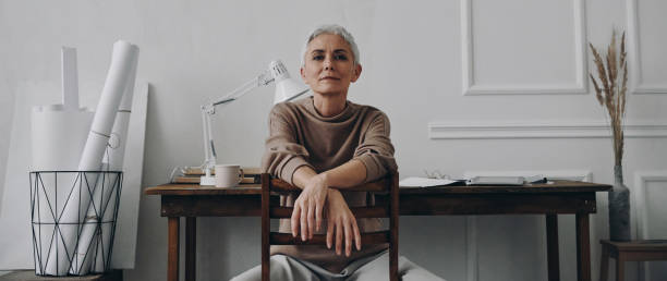 istock Confident senior woman looking at camera while sitting at her creative working place 1479317057