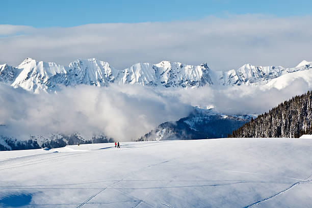 vista panorámica a las montañas y dos personas de senderismo en alpes - snowboard non urban scene woods snowboarding fotografías e imágenes de stock
