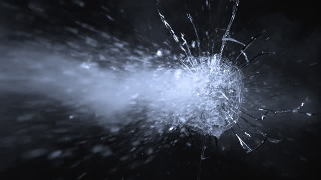 SLO MO LD Bullet piercing through a glass panel and breaking it