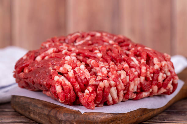 minced meat on wood background. raw minced cow meat or ground meat. close up - ground beef imagens e fotografias de stock