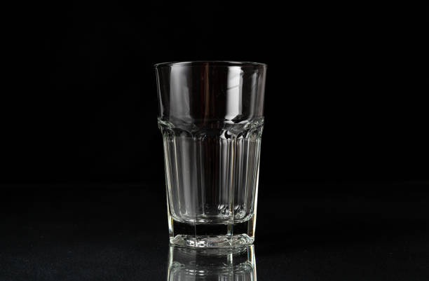istock Empty glass on black background. Empty thick glass tumbler on dark background 1479321839