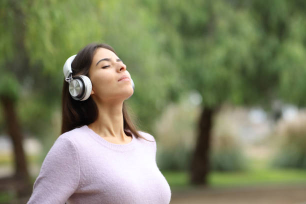 istock Woman breathing with headphone meditating in a park 1479324493