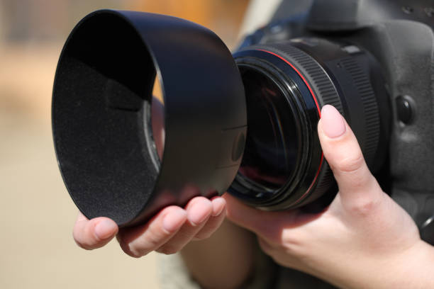 istock Photographer hand installing lens hood 1479324550
