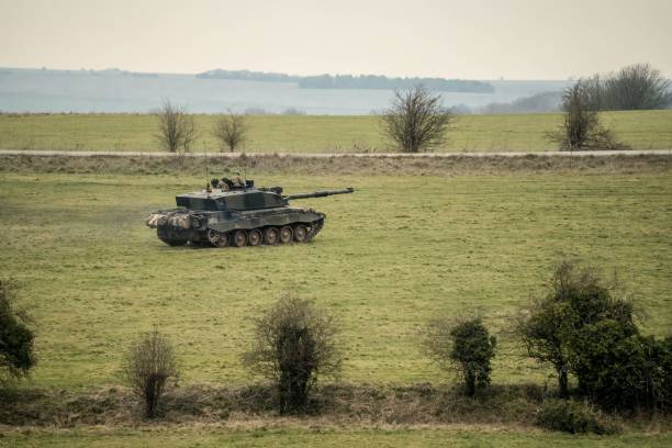 istock Commander gunner challenger situated in a grassy landscape, with trees and shrubs in the background 1479327850