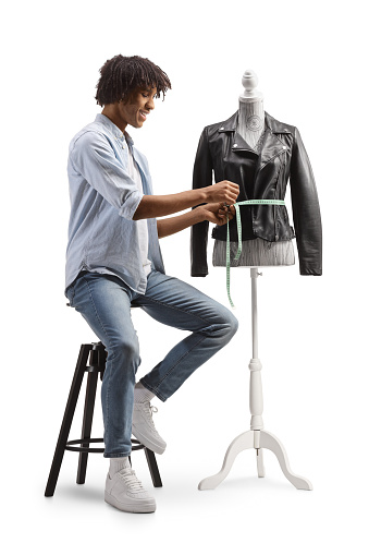 African american fashion designer measuring a jacket on a mannequin isolated on white background