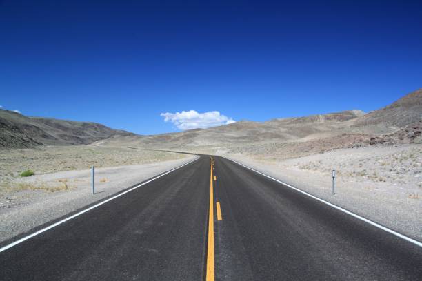 istock Long, straight highway winding its way through a vast desert landscape under a blue sky. 1479329311
