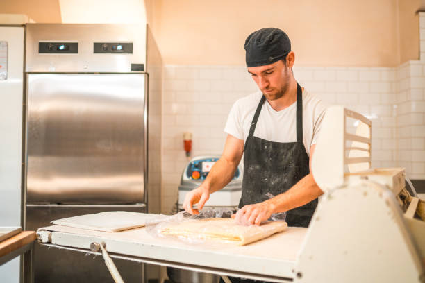 istock Artisan Baker Wrapping Dough Into A Plastic Foil At Artisan Bakery 1479332484