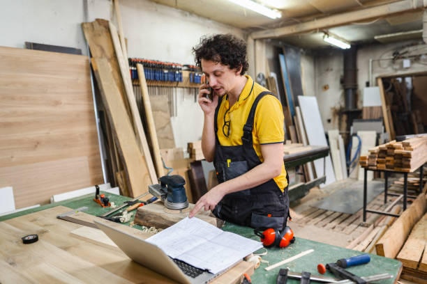 istock Carpenter talking on the phone while working in the woodshop 1479332747