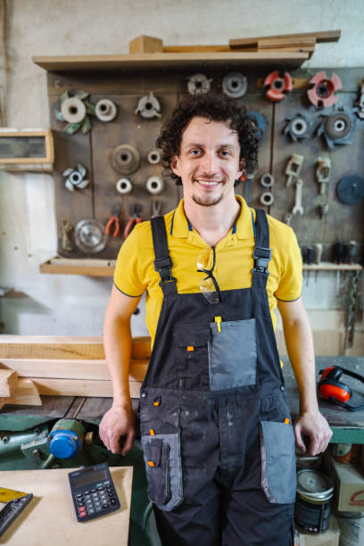 Portrait of a smiling carpenter in the workshop