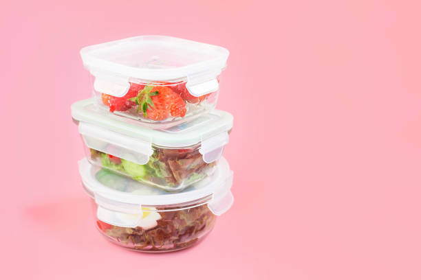 istock Stack of glass lunch boxes with food inside on pink background, copy space. 1479335027