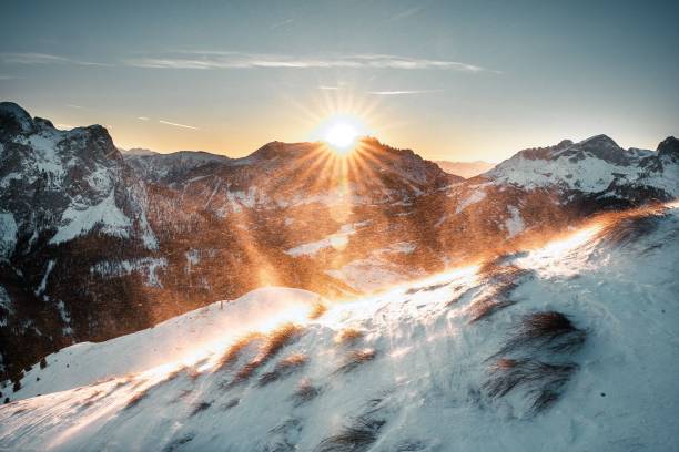 istock Sun shines brightly from behind a snowy mountain landscape 1479338217