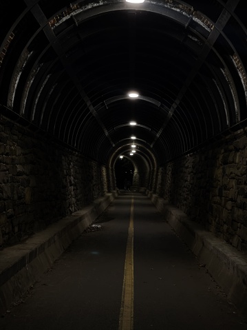 An unpopulated tunnel illuminated by light at night