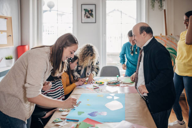 istock People with down syndrome and cerebral palsy doing an art project with help with assistants and animators.Disability health care art workshop. 1479340184