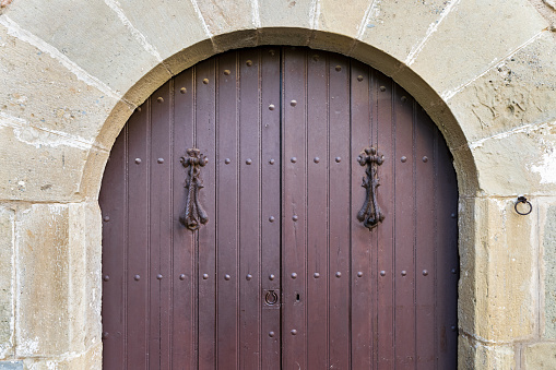 An old arch-shaped wooden entrance door