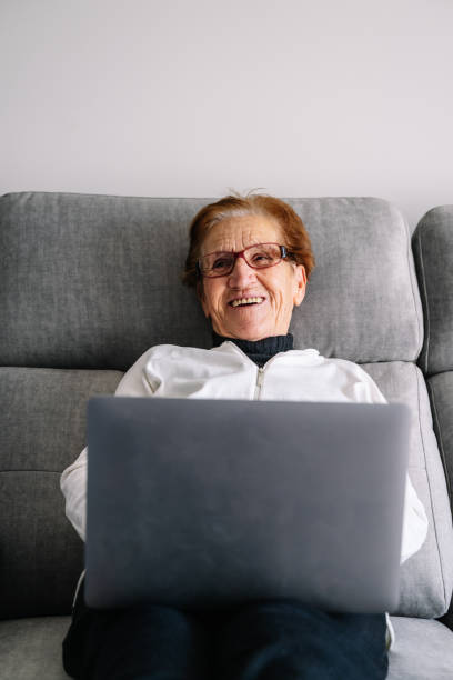 stara babcia używająca laptopa na konferencje z rodziną podczas covidowego porodu - one person lifestyles 80 plus years indoors zdjęcia i obrazy z banku zdjęć