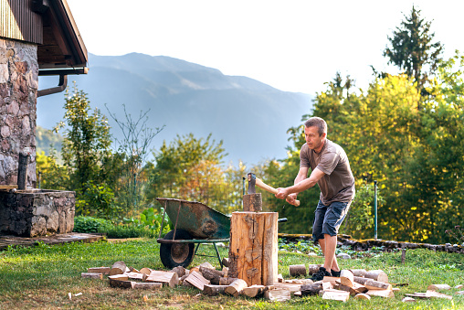 Man Chopping Wood in the Countryside at the Sunset in Summer