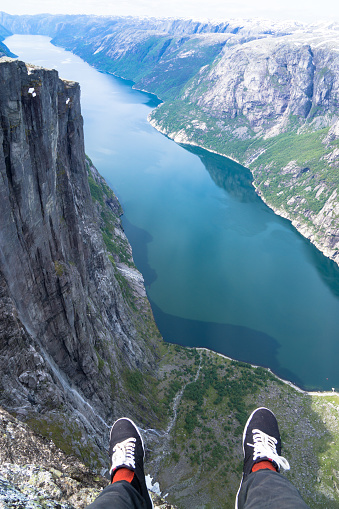 A person sitting on a rock overlooking Lysefjord in Stavanger, Norway