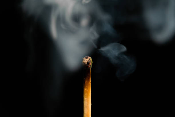 istock A lit match with smoke on a black background, macro photography. An extinguished match with smoke. 1479343663