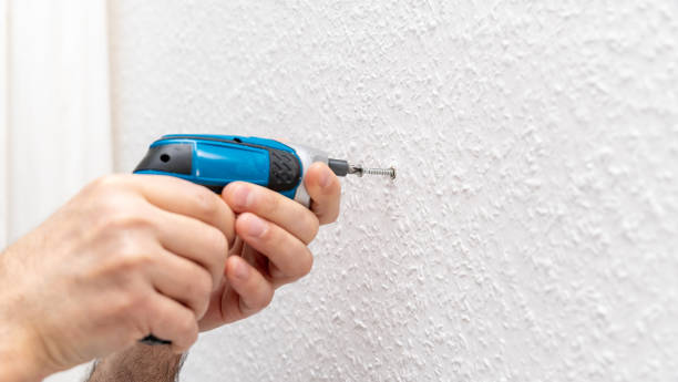 istock Male worker removing dowel from wall with cordless screwdriver 1479344296