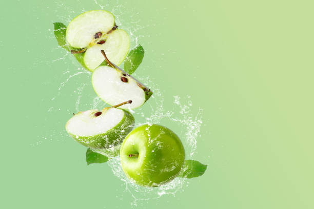 istock Creative layout made from Green Apple and water splashing on a pastel green background. Fruit minimal concept and copy space. 1479346120