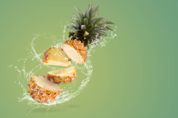istock Creative layout made form Fresh Split Pineapple Fruit and water Splashing on green background. 1479346127