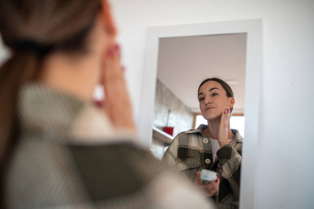 istock Woman applying moisturizer on face 1479346403