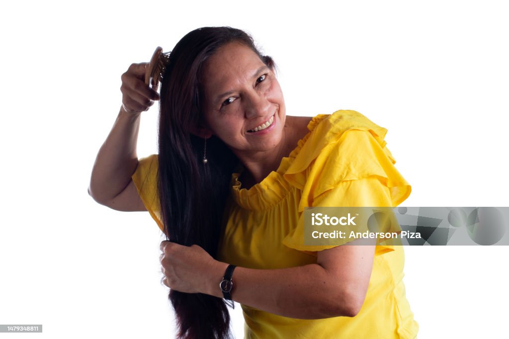 Beautiful Latina Mature Woman Smiling And Brushing Her Long Hair Stock