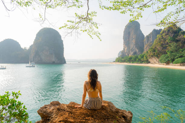 istock Woman sitting on rock and looking at Railey  bay 1479349697