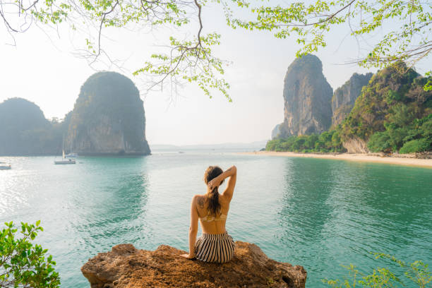 istock Woman sitting on rock and looking at Railey  bay 1479349698