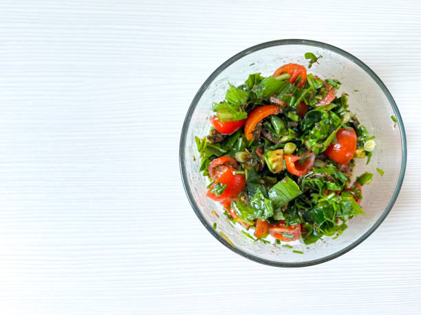 istock Glass plate with salad with wild plants on white background, top view, soft focus 1479350168
