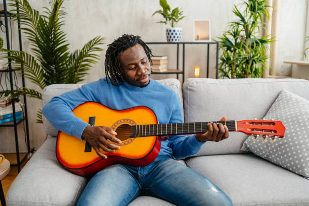 istock Young Man Playing Guitar At Home 1479350835