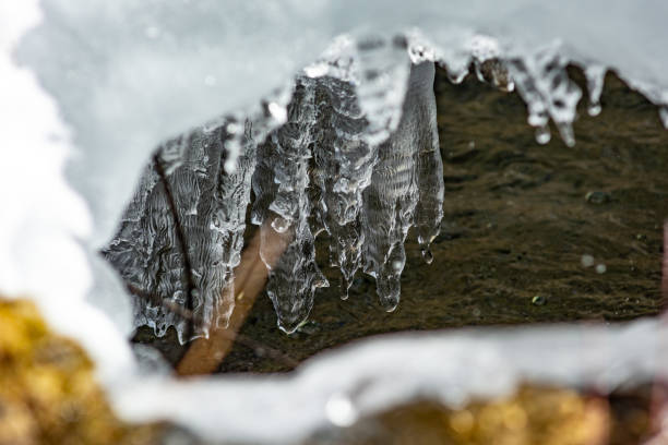 The passage of water through a cavity in the ice during melting