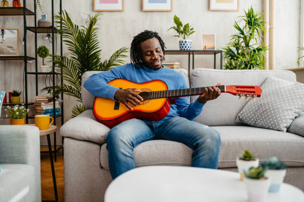 istock Young Man Playing Guitar At Home 1479352917